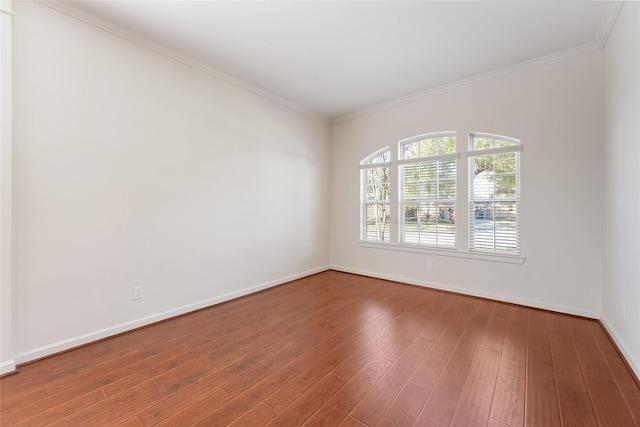 unfurnished room with ornamental molding, hardwood / wood-style floors, and baseboards