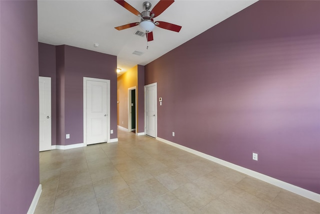 empty room featuring baseboards, visible vents, and ceiling fan