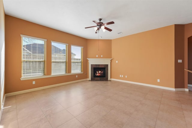 unfurnished living room with visible vents, baseboards, a ceiling fan, and a tile fireplace