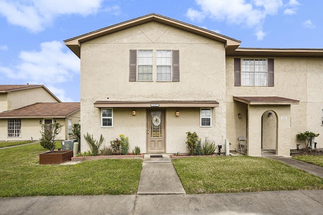 view of property with a front lawn and stucco siding