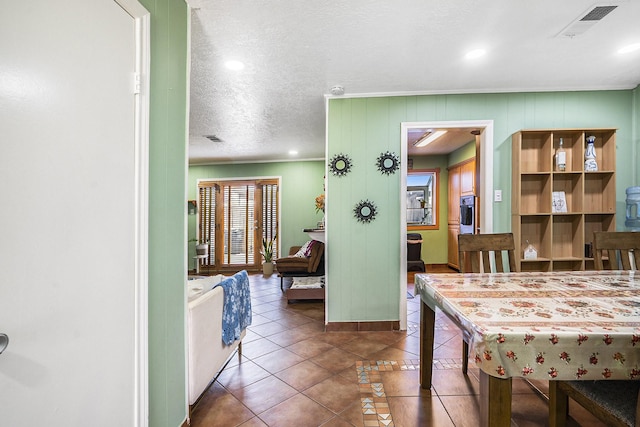 interior space with tile patterned flooring, visible vents, crown molding, and a textured ceiling