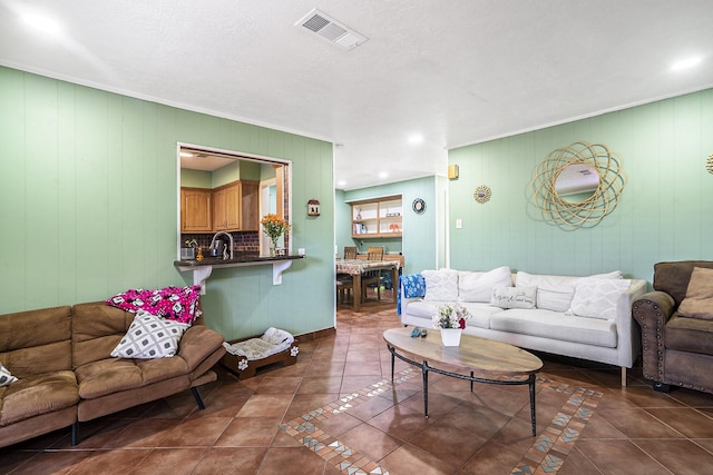 living room featuring ornamental molding, visible vents, and tile patterned floors