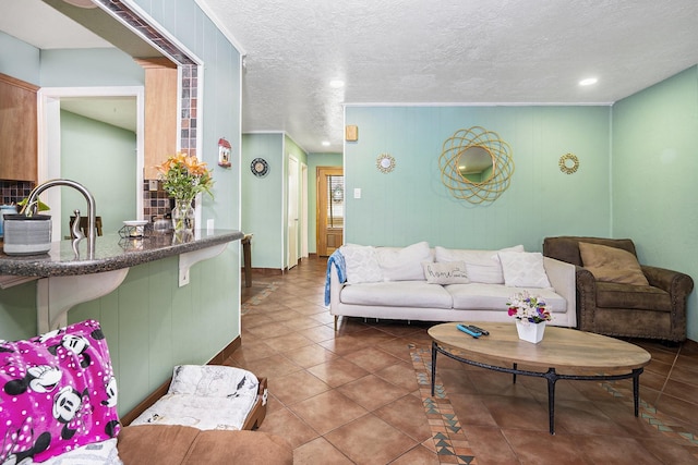 tiled living area with recessed lighting, a sink, and a textured ceiling