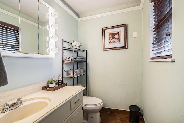 bathroom with crown molding, toilet, vanity, tile patterned flooring, and baseboards