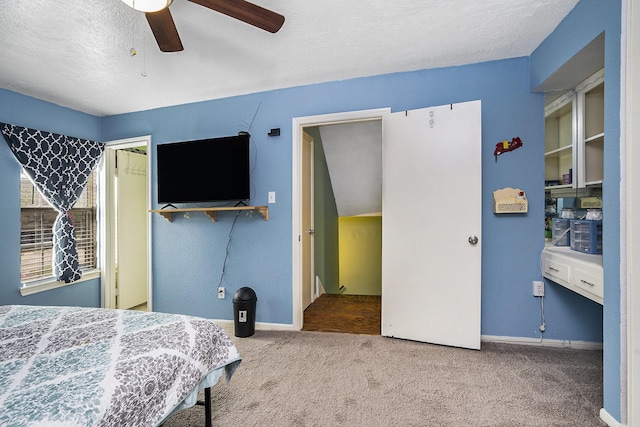 bedroom featuring carpet floors, a textured ceiling, baseboards, and a ceiling fan