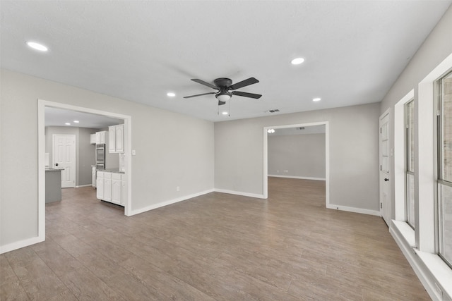 empty room with a ceiling fan, recessed lighting, wood finished floors, and baseboards