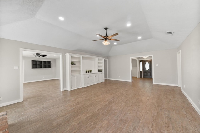 unfurnished living room featuring visible vents, lofted ceiling, light wood-style flooring, and a ceiling fan