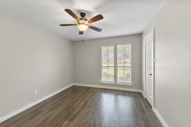 unfurnished room featuring baseboards, a ceiling fan, and dark wood-style flooring