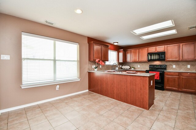 kitchen with black appliances, visible vents, decorative backsplash, and brown cabinetry