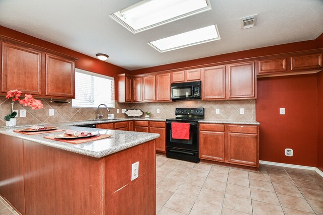 kitchen with visible vents, brown cabinetry, decorative backsplash, a peninsula, and black appliances