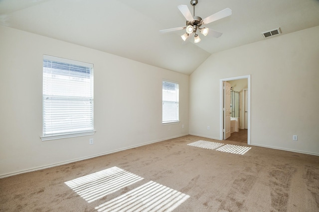 empty room featuring ceiling fan, visible vents, baseboards, vaulted ceiling, and carpet