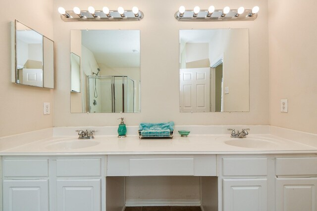 bathroom featuring a stall shower, a sink, and double vanity