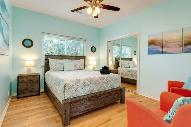 bedroom with a closet, visible vents, ceiling fan, light wood-type flooring, and baseboards