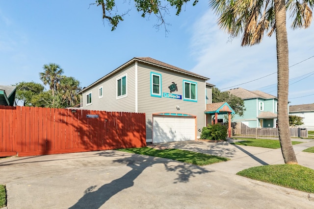 view of front of property with concrete driveway, fence, and an attached garage