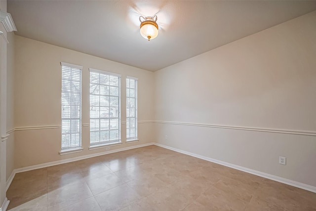 unfurnished room with baseboards and light tile patterned flooring