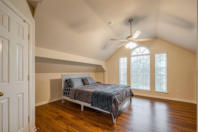 bedroom featuring dark wood-type flooring, vaulted ceiling, baseboards, and a ceiling fan