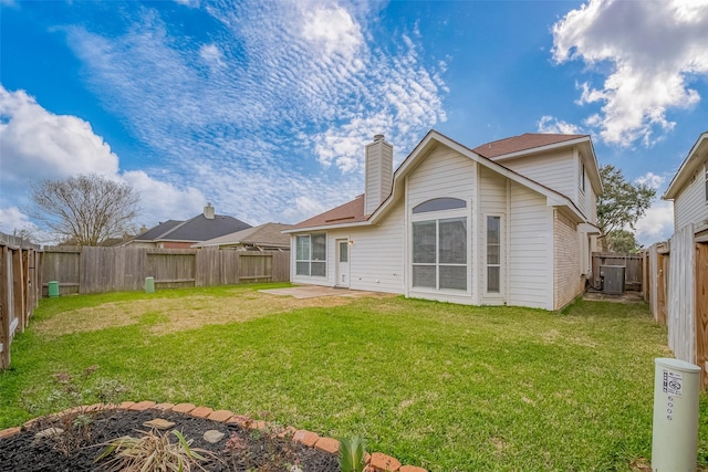 rear view of property with central AC, a chimney, a fenced backyard, and a lawn