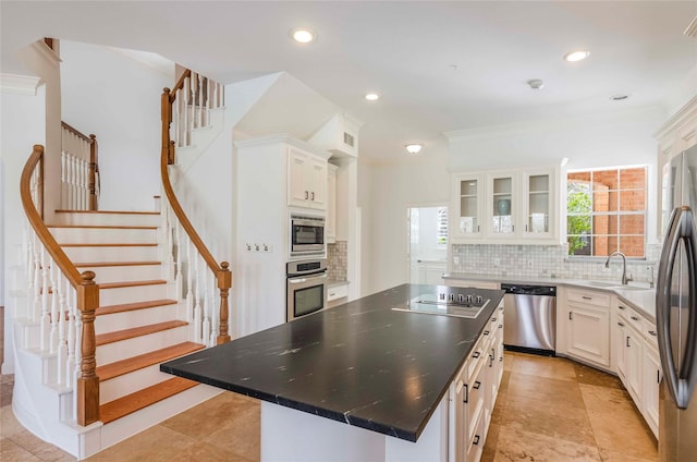 kitchen with stainless steel appliances, decorative backsplash, glass insert cabinets, a kitchen island, and a sink