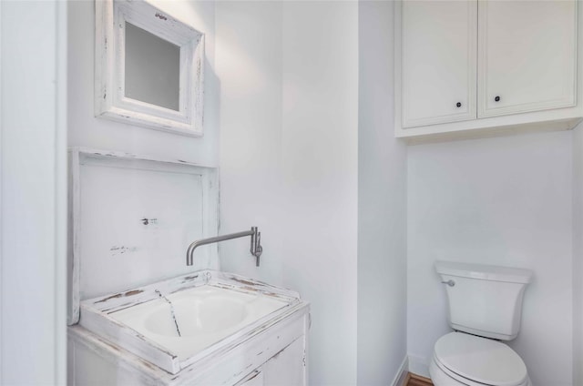 half bathroom with vanity and toilet