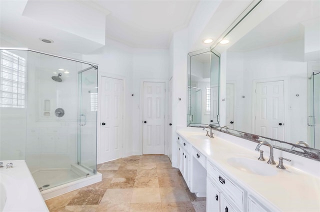 bathroom featuring ornamental molding, a sink, a shower stall, and double vanity