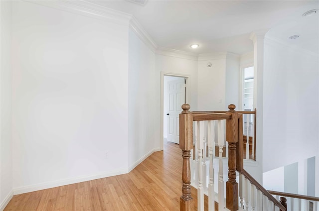 corridor featuring baseboards, light wood-style flooring, ornamental molding, an upstairs landing, and recessed lighting