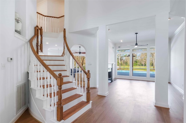 stairs featuring baseboards, visible vents, ceiling fan, and wood finished floors