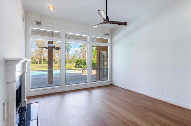 interior space with wood finished floors, a ceiling fan, and crown molding