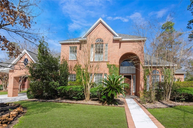 view of front of property featuring brick siding and a front lawn