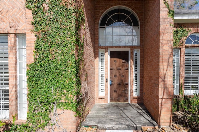 doorway to property with brick siding