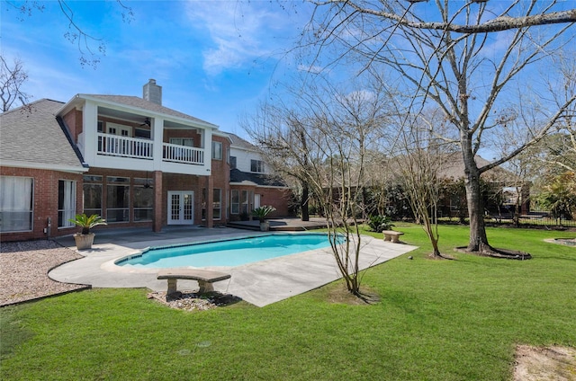 outdoor pool with french doors, a patio area, a lawn, and ceiling fan