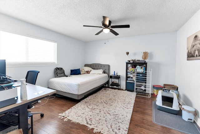 bedroom with a textured ceiling, a ceiling fan, and dark wood-type flooring