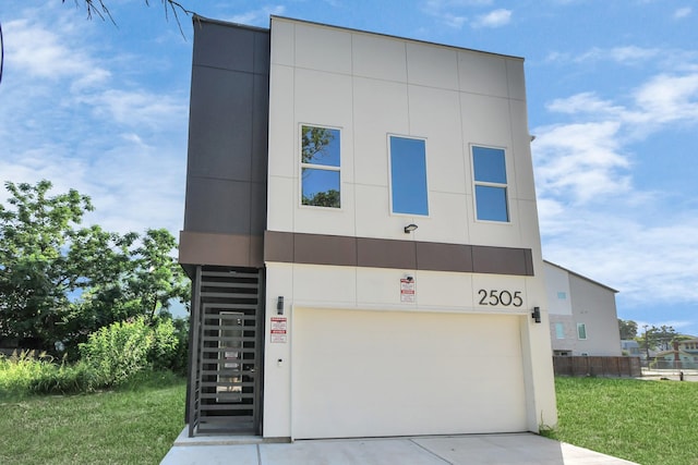 view of front facade with a garage, concrete driveway, stairway, and stucco siding