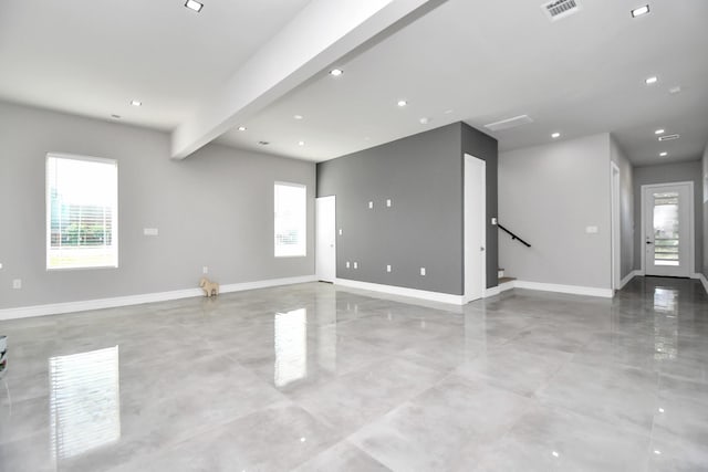 spare room featuring beamed ceiling, visible vents, and baseboards