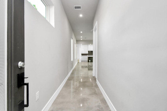 hallway featuring recessed lighting, visible vents, concrete floors, and baseboards