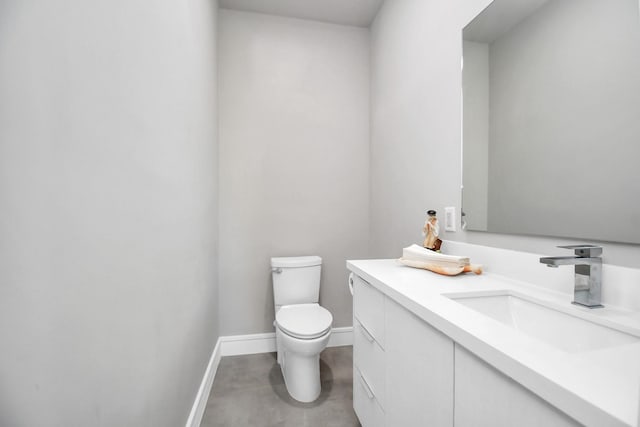 bathroom with vanity, toilet, and baseboards