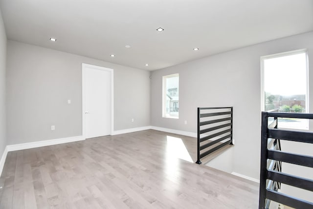 spare room featuring recessed lighting, baseboards, and wood finished floors