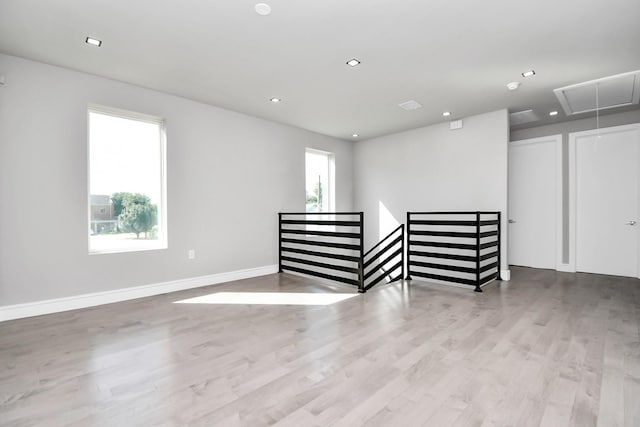 spare room with plenty of natural light, attic access, wood finished floors, and recessed lighting