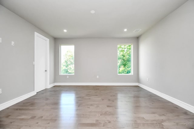 spare room with recessed lighting, wood finished floors, and baseboards