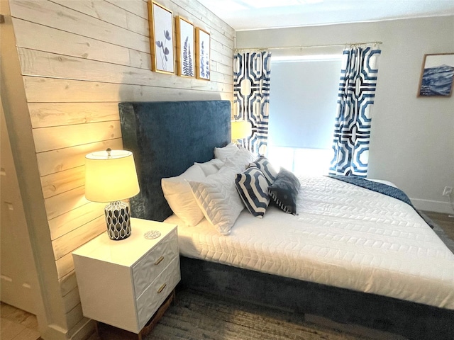 bedroom with wooden walls and baseboards