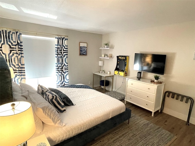 bedroom with baseboards and wood finished floors