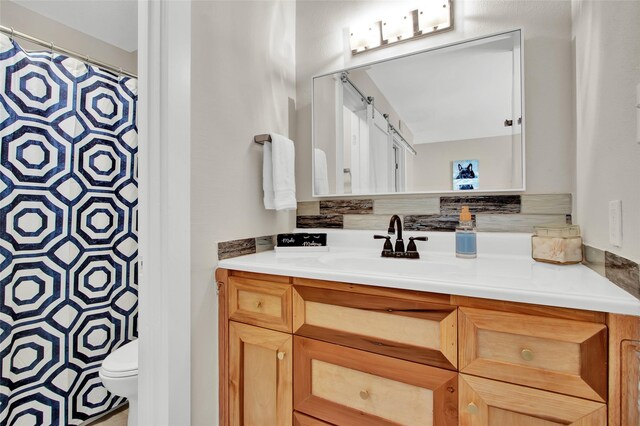 bathroom featuring toilet, curtained shower, and vanity