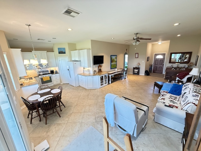 living room with ceiling fan, arched walkways, light tile patterned flooring, recessed lighting, and visible vents