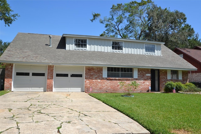 view of front facade with brick siding, roof with shingles, a front yard, a garage, and driveway