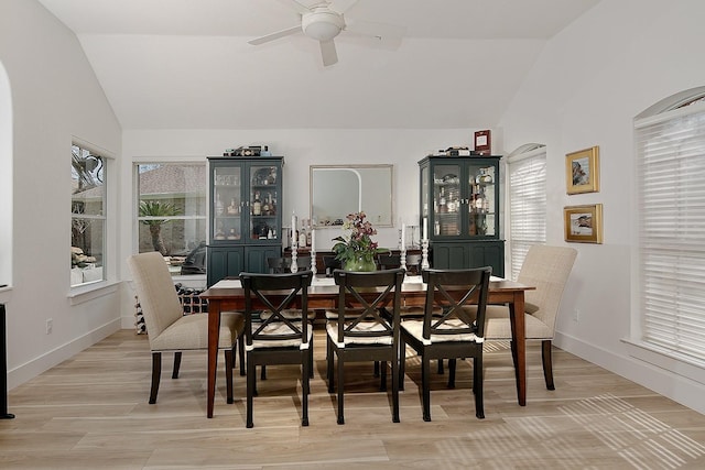 dining area with a wealth of natural light, light wood-type flooring, a ceiling fan, and vaulted ceiling