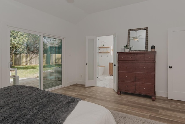 bedroom with access to exterior, connected bathroom, baseboards, lofted ceiling, and light wood-style flooring