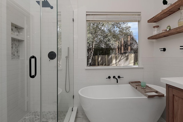 bathroom with a soaking tub, tile walls, and a stall shower