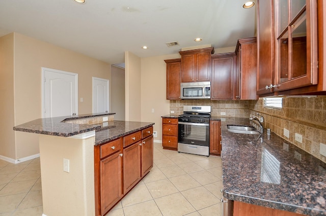 kitchen featuring stainless steel appliances, visible vents, backsplash, light tile patterned flooring, and a sink