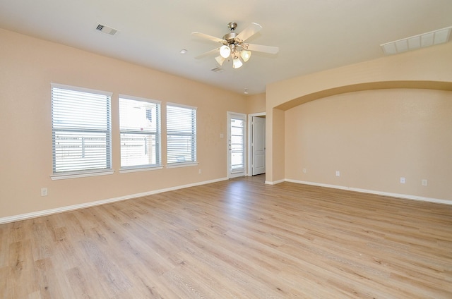 empty room featuring visible vents, ceiling fan, light wood-style flooring, and baseboards