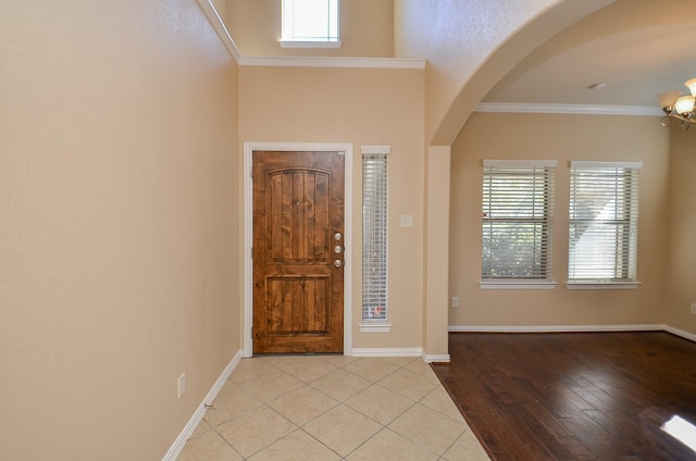 entryway featuring ornamental molding, baseboards, and light tile patterned floors