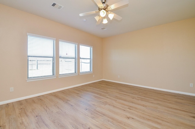 unfurnished room with light wood-style floors, baseboards, and visible vents